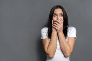 woman-covering-mouth-and-looking-concerned