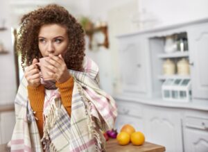 woman-huddled-under-blanket