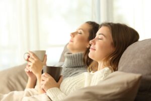 two-women-leaning-back-on-couch-looking-comfortable