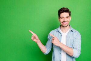 man-pointing-upward-on-green-background